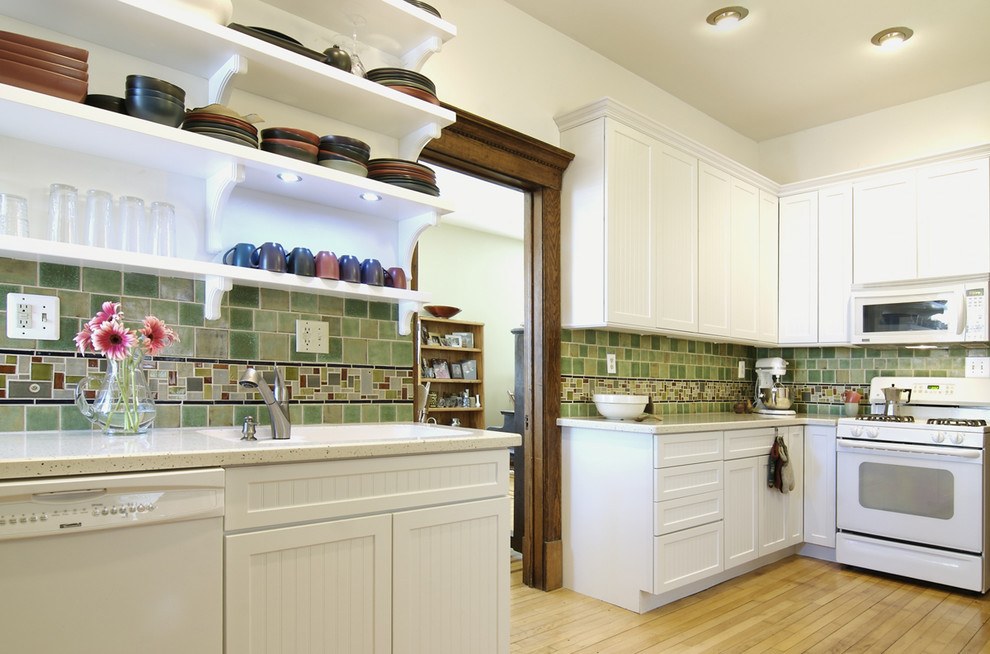 This is an example of a mid-sized traditional l-shaped separate kitchen in Other with white appliances, open cabinets, white cabinets, green splashback, an undermount sink, ceramic splashback, light hardwood floors and no island.