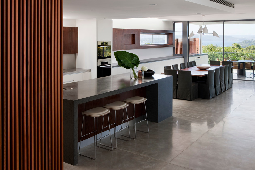 This is an example of a large contemporary kitchen/dining combo in Sydney with white walls.