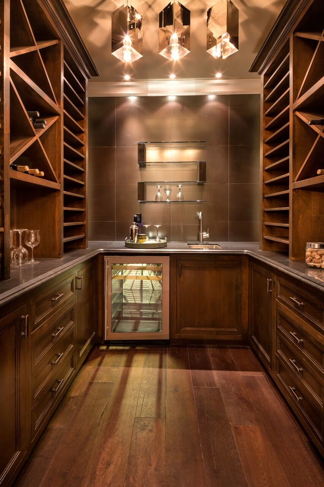 Inspiration for a traditional u-shaped wet bar in Los Angeles with an undermount sink, recessed-panel cabinets, dark wood cabinets, brown splashback and dark hardwood floors.