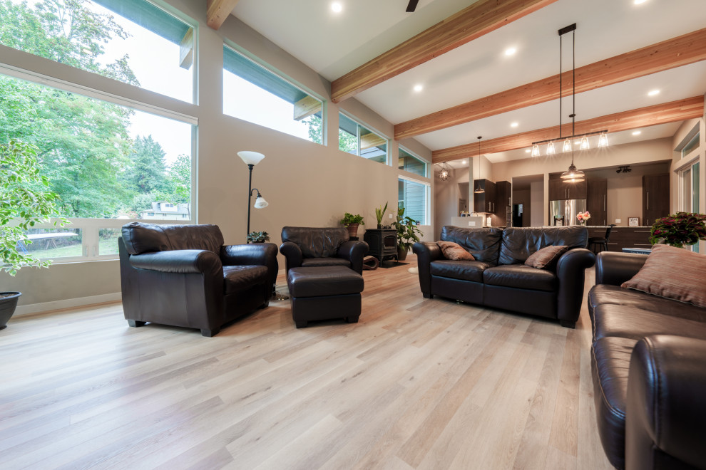 Photo of a large contemporary formal open plan living room in Seattle with white walls, vinyl flooring, no fireplace, a wall mounted tv, beige floors and exposed beams.