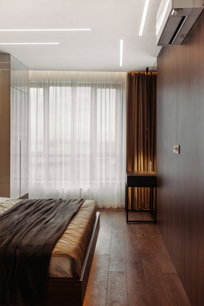Kleines Modernes Schlafzimmer mit brauner Wandfarbe, Laminat, braunem Boden und Holzwänden in Sankt Petersburg