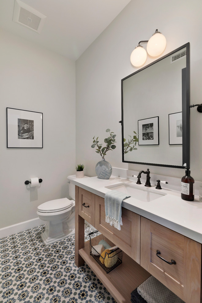 This is an example of a country bathroom in Los Angeles with light wood cabinets, grey walls, an undermount sink, multi-coloured floor, white benchtops and shaker cabinets.