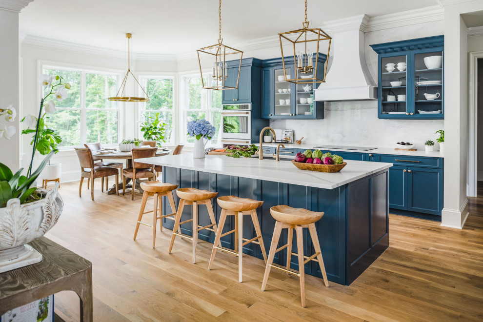 This is an example of a mid-sized traditional kitchen in Charlotte with a drop-in sink, shaker cabinets, blue cabinets, quartz benchtops, yellow splashback, engineered quartz splashback, white appliances, light hardwood floors, with island, white floor and yellow benchtop.