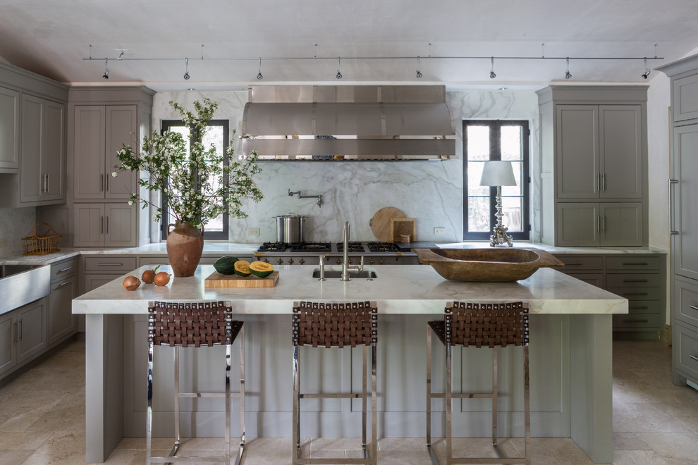 Inspiration for a mid-sized transitional u-shaped eat-in kitchen in DC Metro with a farmhouse sink, recessed-panel cabinets, grey cabinets, marble benchtops, grey splashback, stainless steel appliances, travertine floors and with island.