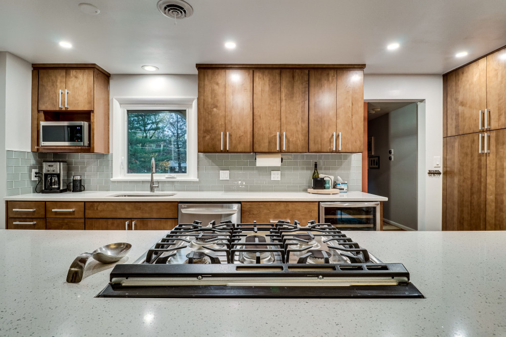 Photo of a mid-sized midcentury galley kitchen in DC Metro with an undermount sink, quartz benchtops, stainless steel appliances and a peninsula.