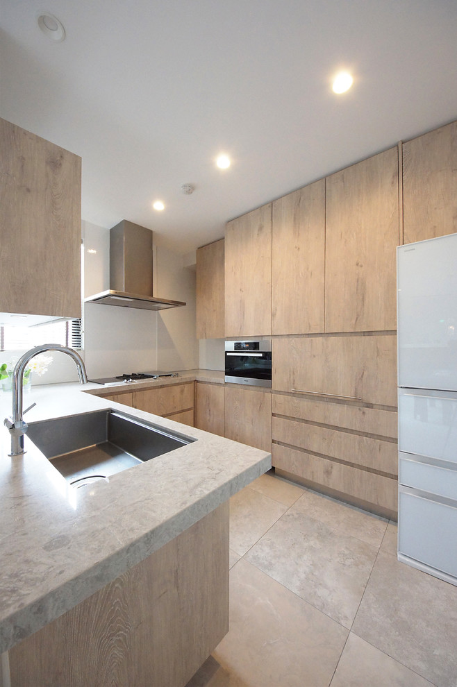 Mid-sized modern u-shaped open plan kitchen in Tokyo with an undermount sink, flat-panel cabinets, beige cabinets, quartzite benchtops, white splashback, white appliances and no island.
