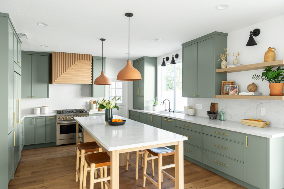 Foto på ett funkis vit u-kök, med en undermonterad diskho, skåp i shakerstil, gröna skåp, bänkskiva i kvarts, flerfärgad stänkskydd, integrerade vitvaror, mellanmörkt trägolv, en köksö och brunt golv