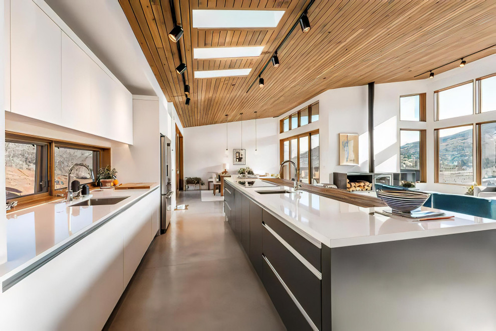 Mid-sized modern galley open plan kitchen in Other with an undermount sink, flat-panel cabinets, white cabinets, quartz benchtops, stainless steel appliances, concrete floors, with island, grey floor, white benchtop and wood.