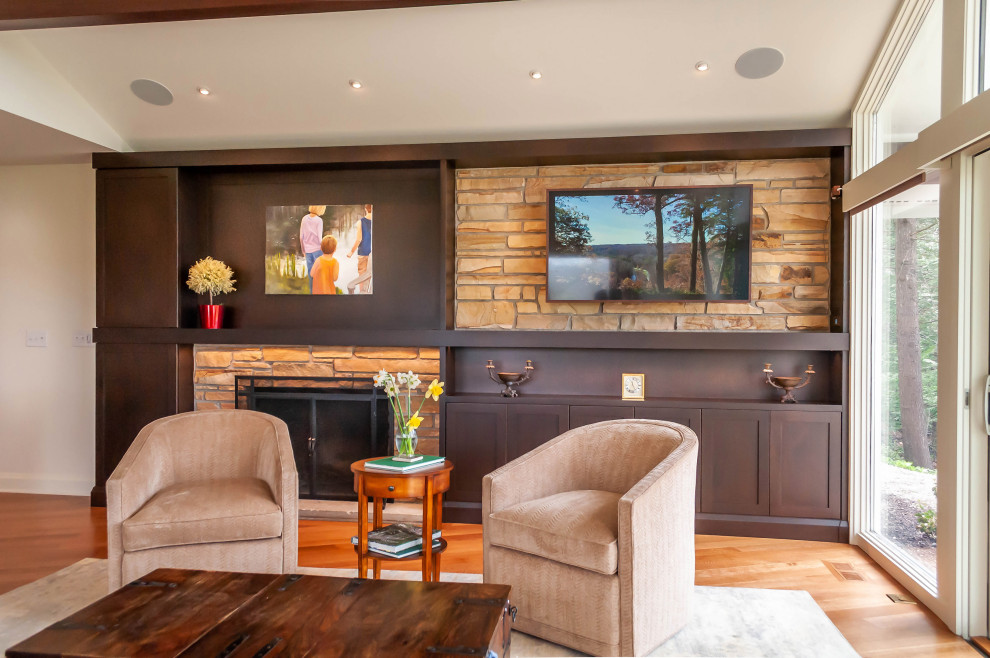 Medium sized retro open plan games room in Cleveland with white walls, medium hardwood flooring, a standard fireplace, a stone fireplace surround, brown floors and a vaulted ceiling.