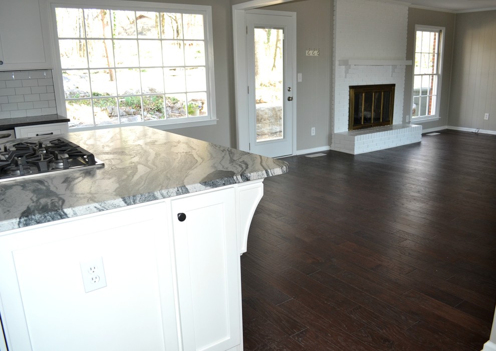 Example of a large transitional l-shaped dark wood floor open concept kitchen design with a farmhouse sink, shaker cabinets, white cabinets, marble countertops, white backsplash, subway tile backsplash, stainless steel appliances and an island