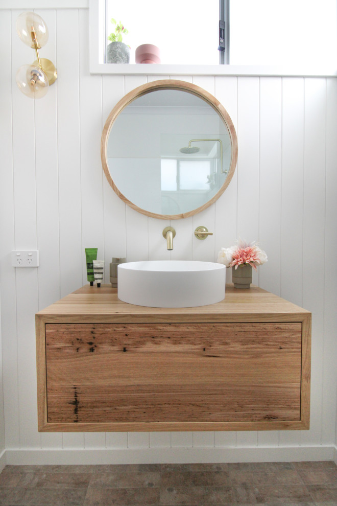 Пример оригинального дизайна: маленькая ванная комната в скандинавском стиле с плоскими фасадами, темными деревянными фасадами, открытым душем, унитазом-моноблоком, белой плиткой, керамической плиткой, белыми стенами, полом из керамогранита, душевой кабиной, настольной раковиной, столешницей из дерева, разноцветным полом, открытым душем, тумбой под одну раковину, подвесной тумбой и панелями на стенах для на участке и в саду