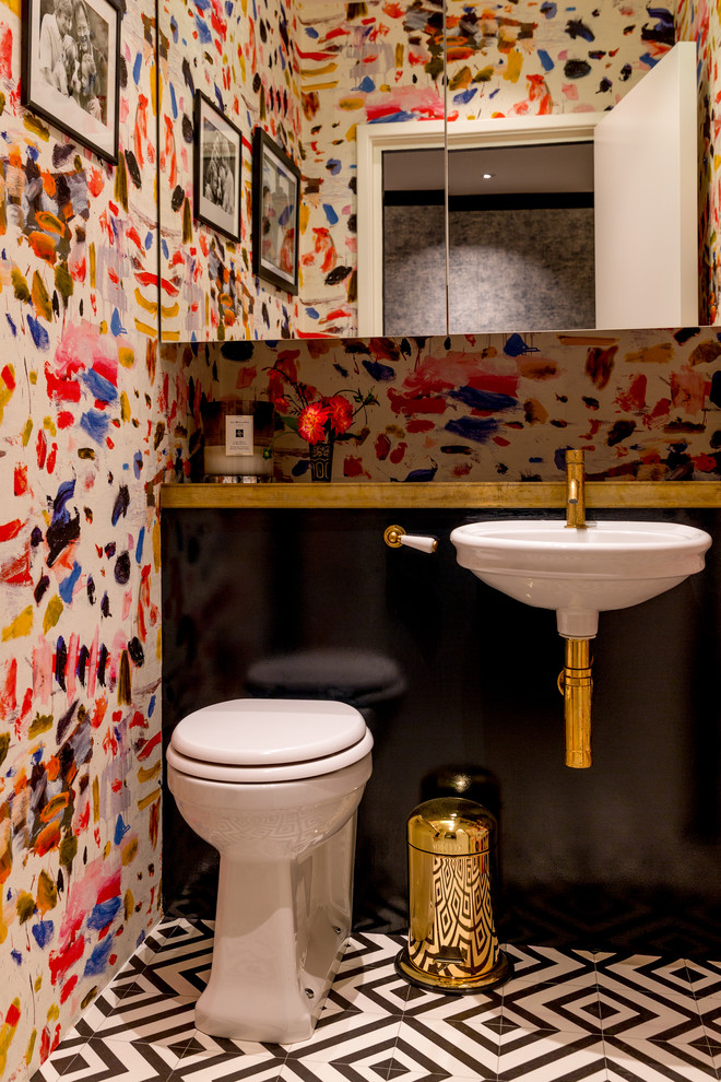 Design ideas for a small eclectic powder room in London with black cabinets, a one-piece toilet, multi-coloured tile, multi-coloured walls, ceramic floors, a wall-mount sink, wood benchtops, black floor and black benchtops.