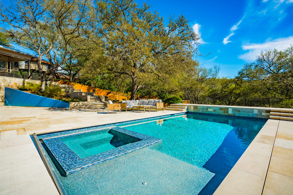 Design ideas for a large traditional backyard rectangular pool in Austin with a hot tub and natural stone pavers.