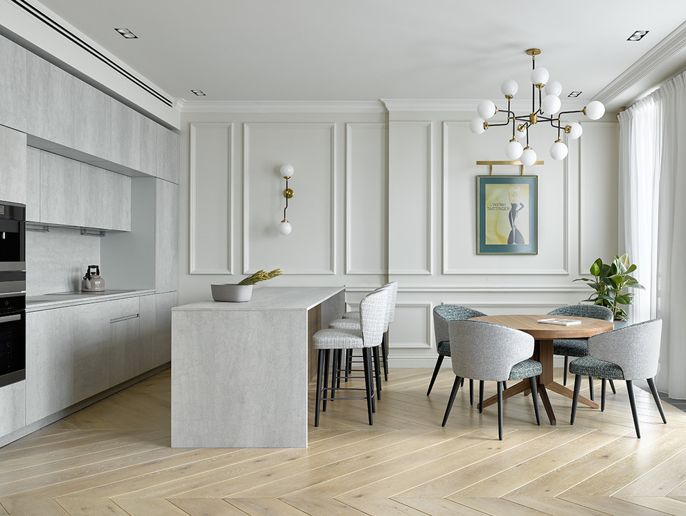 This is an example of a transitional single-wall open plan kitchen in Moscow with flat-panel cabinets, grey cabinets, grey splashback, stainless steel appliances, light hardwood floors, with island and beige floor.