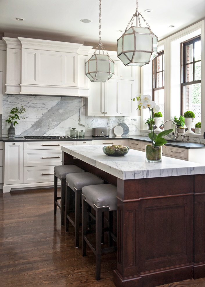 Large elegant l-shaped dark wood floor kitchen photo in Montreal with an undermount sink, recessed-panel cabinets, white cabinets, marble countertops, gray backsplash, paneled appliances, an island and marble backsplash