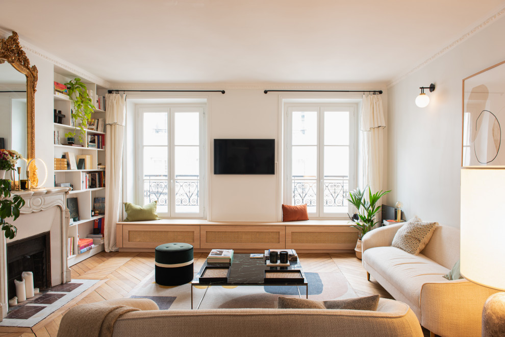 Mittelgroßes, Offenes Modernes Wohnzimmer mit beiger Wandfarbe, hellem Holzboden, Kamin, Kaminumrandung aus Stein und TV-Wand in Paris