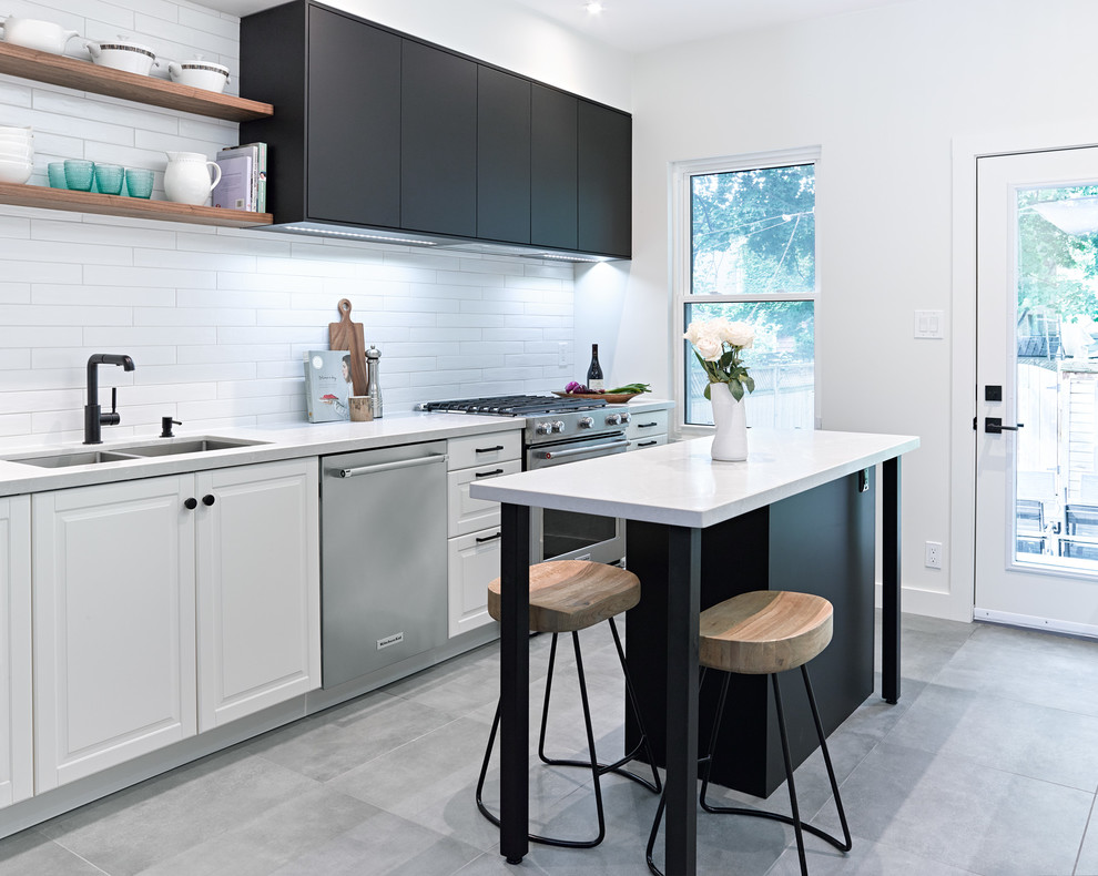 Enclosed kitchen - mid-sized transitional galley porcelain tile and gray floor enclosed kitchen idea in Toronto with an undermount sink, recessed-panel cabinets, quartz countertops, white backsplash, subway tile backsplash, stainless steel appliances and an island