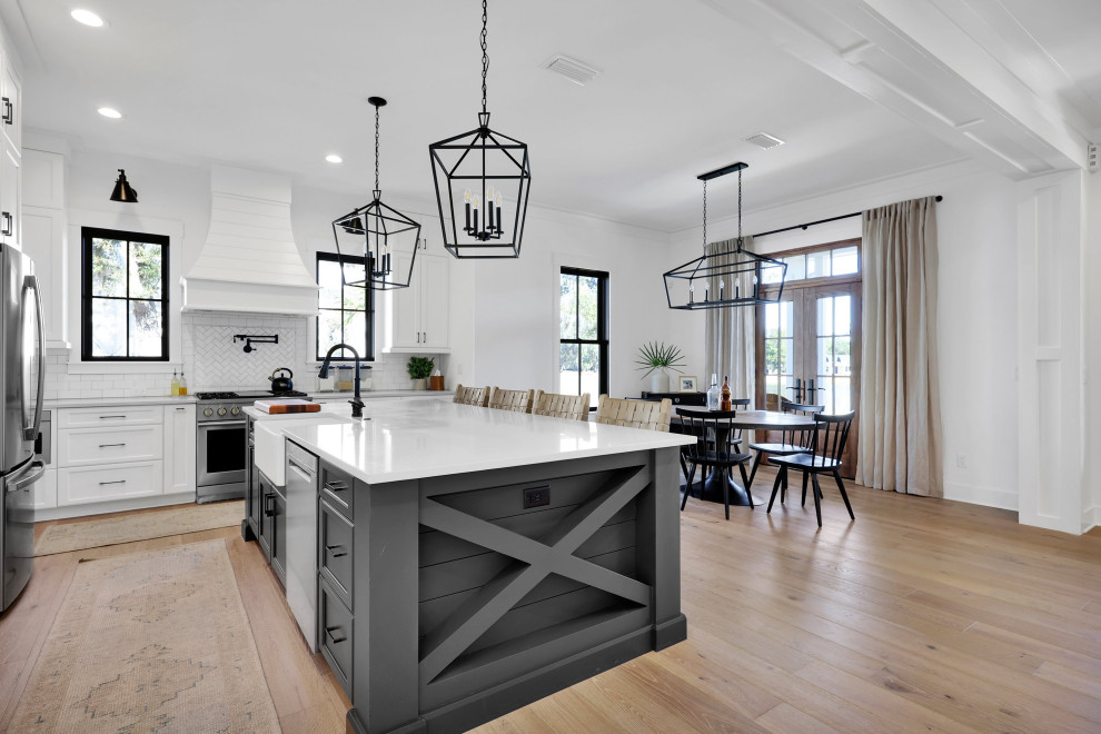 Example of a huge farmhouse light wood floor and brown floor kitchen design in Jacksonville with a farmhouse sink, open cabinets, white cabinets, quartz countertops, white backsplash, mosaic tile backsplash, stainless steel appliances, an island and white countertops
