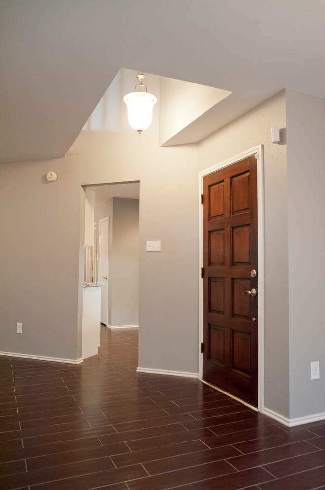 Photo of a mid-sized transitional foyer in Houston with grey walls, porcelain floors, a single front door and a medium wood front door.