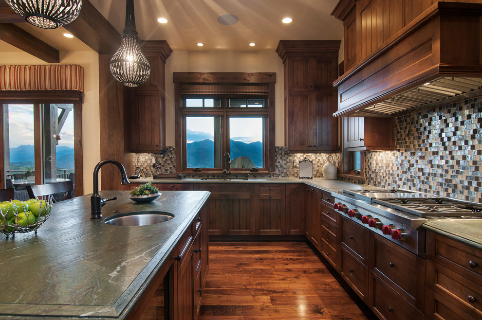 This is an example of a country kitchen in Salt Lake City with recessed-panel cabinets, dark wood cabinets and multi-coloured splashback.