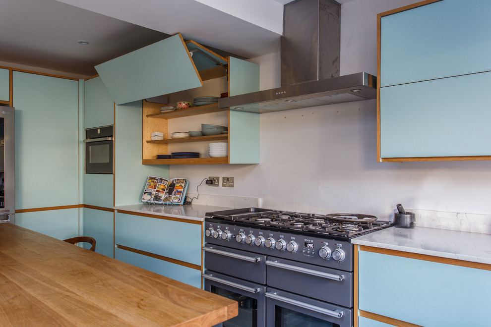 Inspiration for a mid-sized midcentury l-shaped eat-in kitchen in Sussex with a drop-in sink, flat-panel cabinets, blue cabinets, quartzite benchtops, stainless steel appliances, with island and white benchtop.