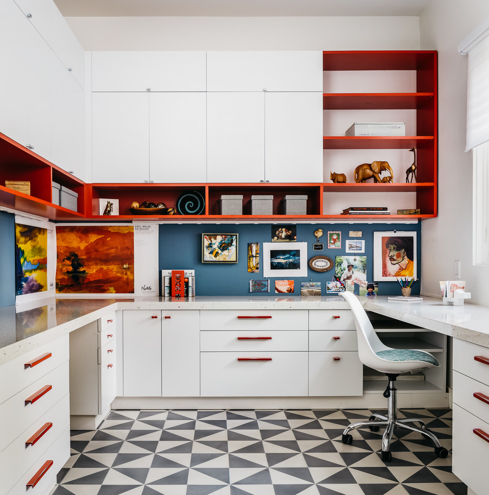 This is an example of a mid-sized transitional home office in San Francisco with white walls, no fireplace, a built-in desk and multi-coloured floor.