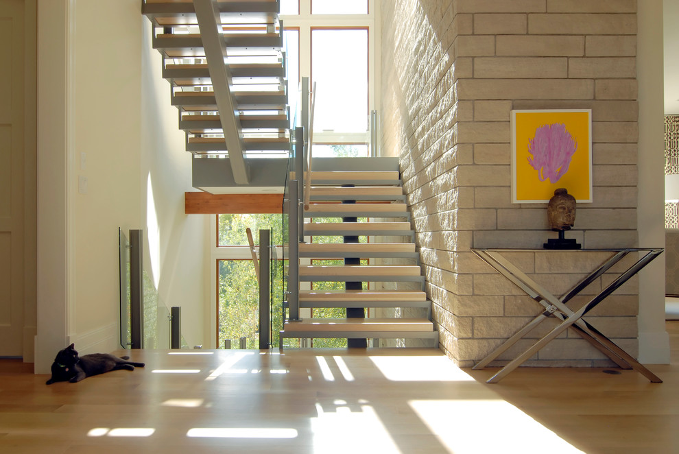 This is an example of a large contemporary wood l-shaped staircase in Denver with open risers and glass railing.