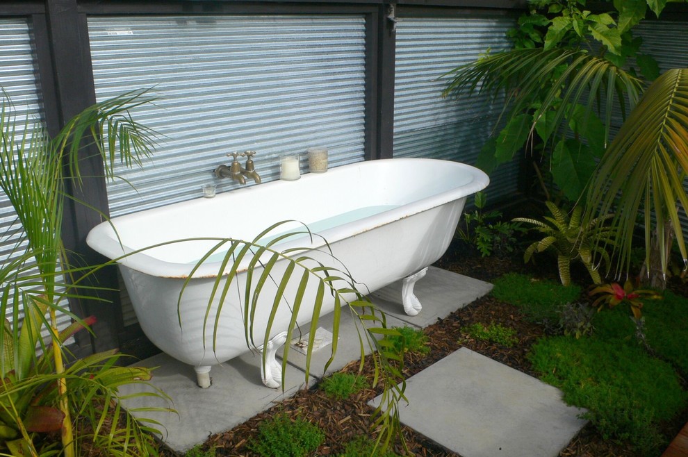 This is an example of a small asian backyard partial sun garden in Auckland with concrete pavers.