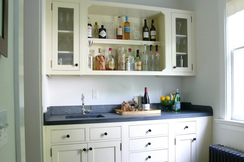 Small traditional galley wet bar in Bridgeport with an integrated sink, beige cabinets, soapstone benchtops, grey splashback and stone slab splashback.
