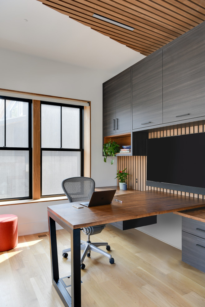 Cette image montre un grand bureau design avec un mur blanc, parquet clair, aucune cheminée, un bureau intégré, un sol marron et un plafond en bois.