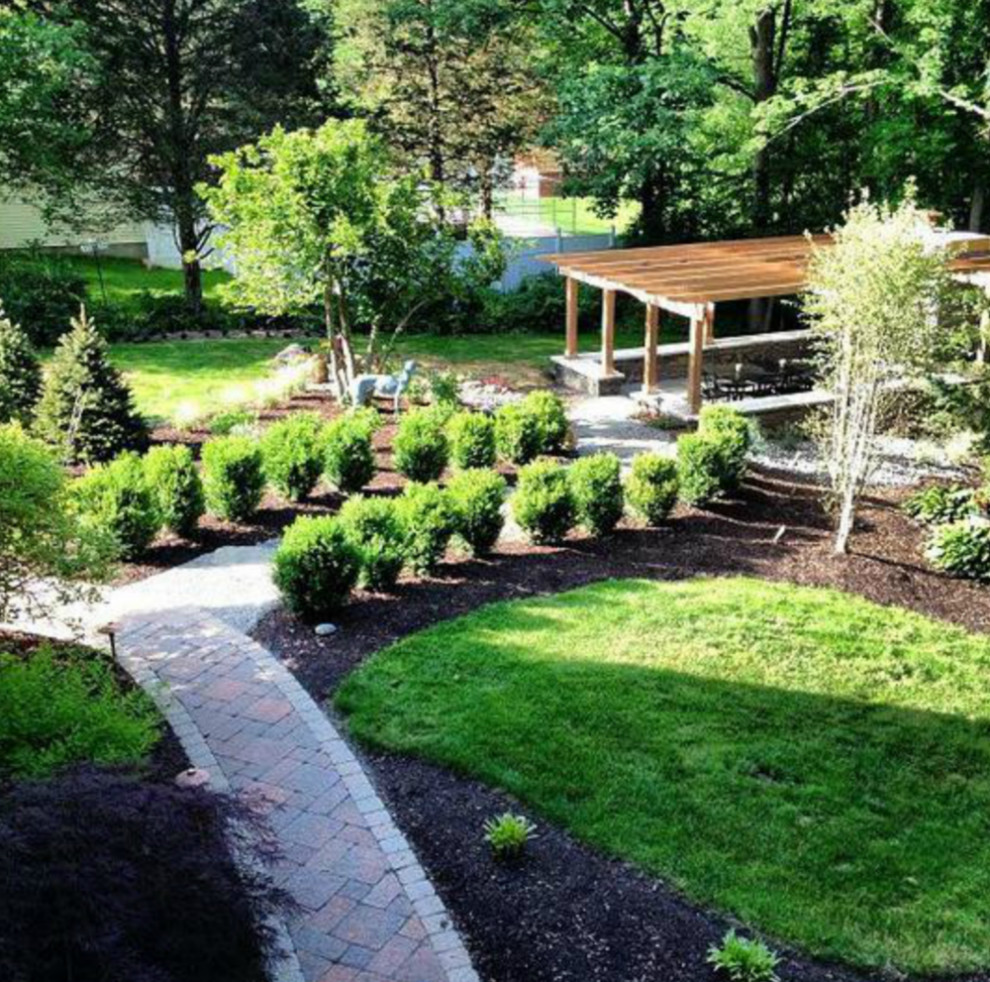 Traditional backyard partial sun formal garden in New York with with path and concrete pavers for spring.