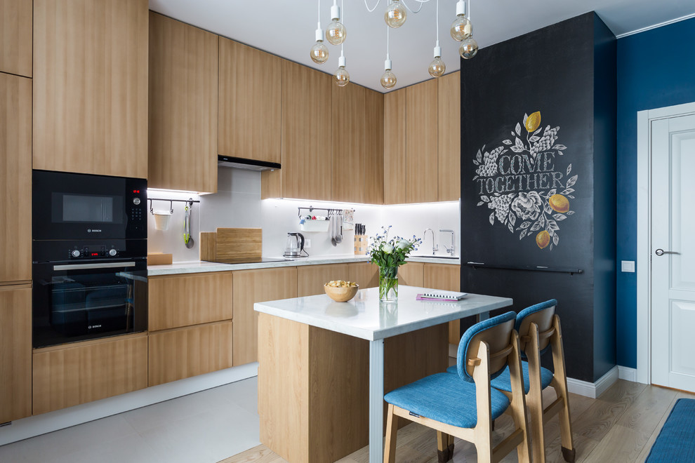 Photo of a contemporary l-shaped kitchen in Saint Petersburg with a double-bowl sink, flat-panel cabinets, solid surface benchtops, white splashback, porcelain splashback, black appliances, porcelain floors, white floor, light wood cabinets, with island and white benchtop.