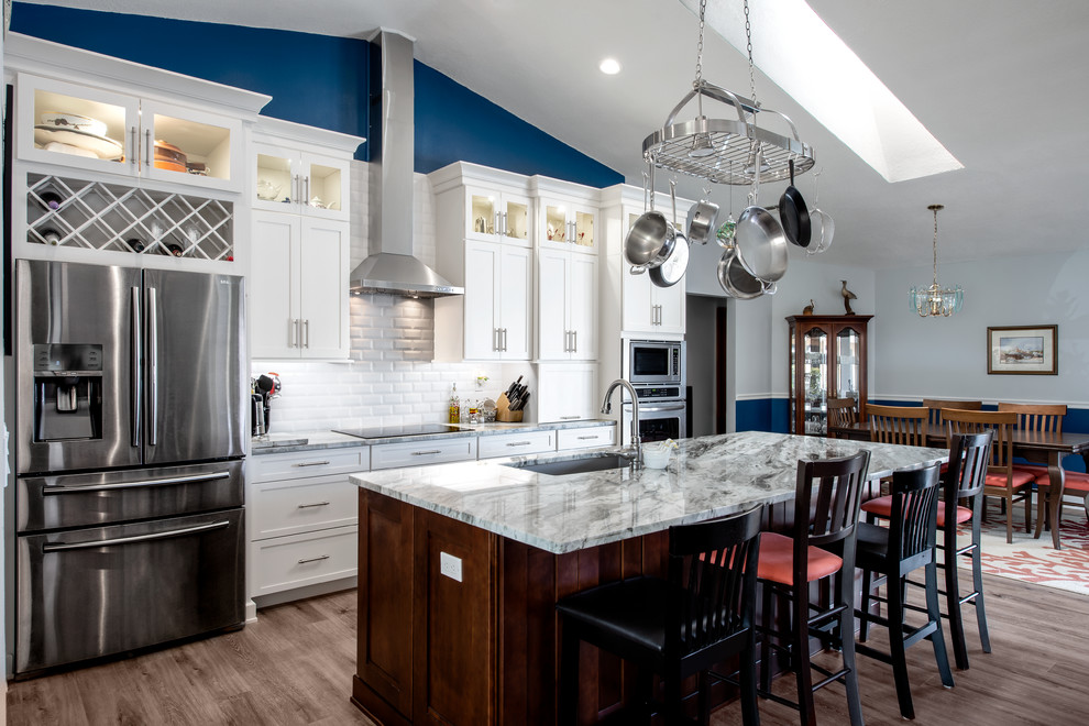 Design ideas for a large traditional eat-in kitchen in Tampa with a single-bowl sink, white cabinets, granite benchtops, white splashback, stainless steel appliances, vinyl floors, with island, brown floor, grey benchtop, shaker cabinets and subway tile splashback.