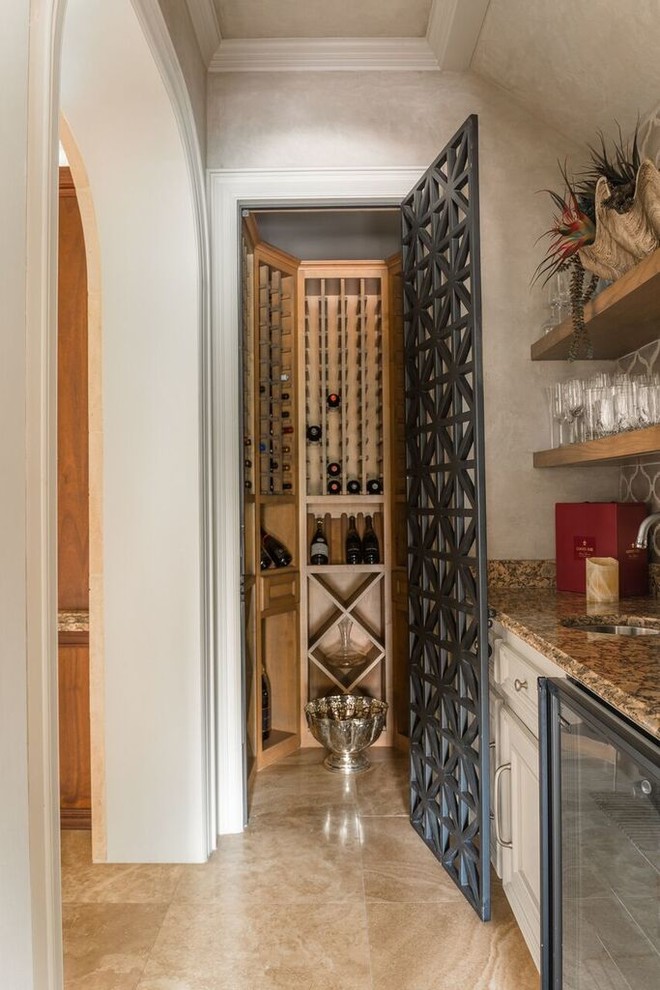 Photo of a small mediterranean wine cellar in Houston with marble floors, storage racks and brown floor.