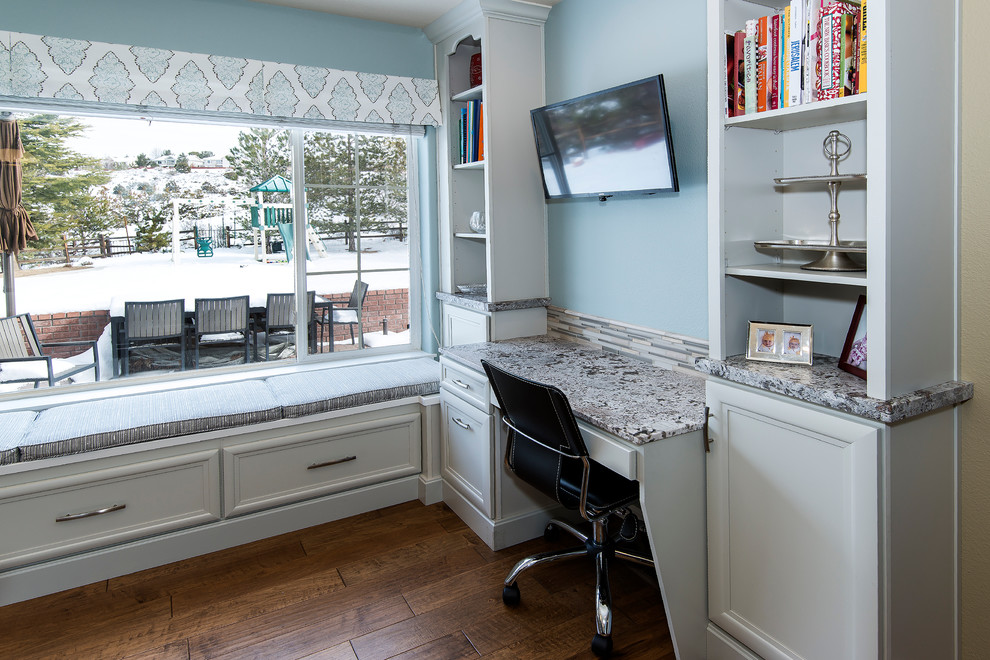 Example of a large transitional medium tone wood floor enclosed kitchen design with a farmhouse sink, recessed-panel cabinets, white cabinets, granite countertops, multicolored backsplash, matchstick tile backsplash, stainless steel appliances and an island