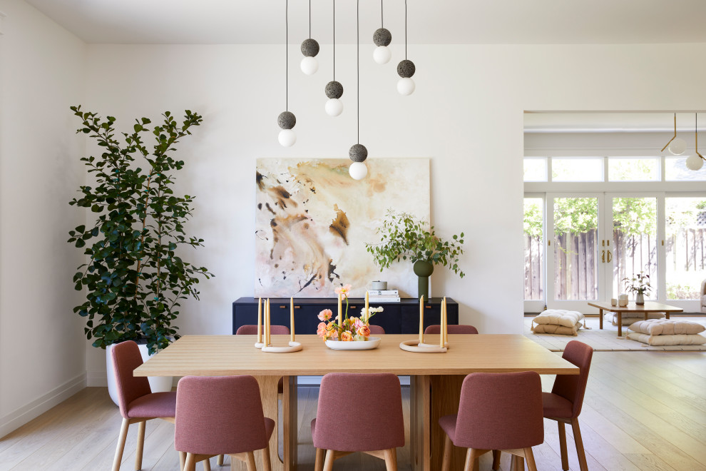 Inredning av en minimalistisk mellanstor matplats med öppen planlösning, med vita väggar, ljust trägolv och brunt golv
