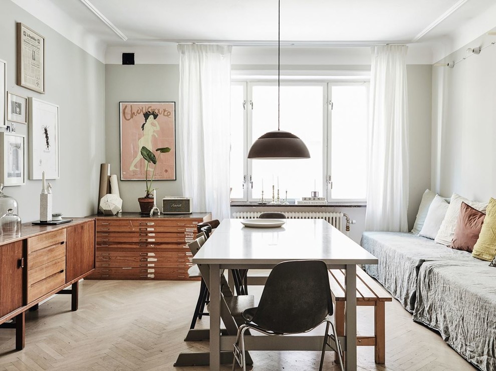 Photo of a mid-sized scandinavian separate dining room in Malmo with grey walls, light hardwood floors and beige floor.