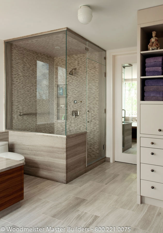 Inspiration for a mid-sized traditional master bathroom in Boston with a drop-in tub, a corner shower, furniture-like cabinets, medium wood cabinets, light hardwood floors, an undermount sink and marble benchtops.