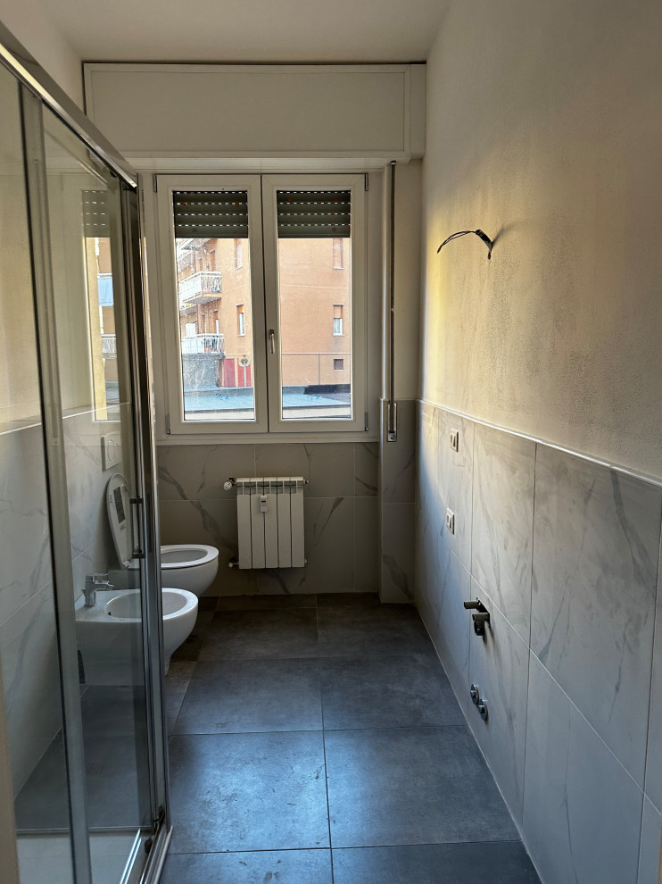 Design ideas for a mid-sized contemporary powder room in Milan with a wall-mount toilet, gray tile, porcelain tile, white walls, porcelain floors and grey floor.
