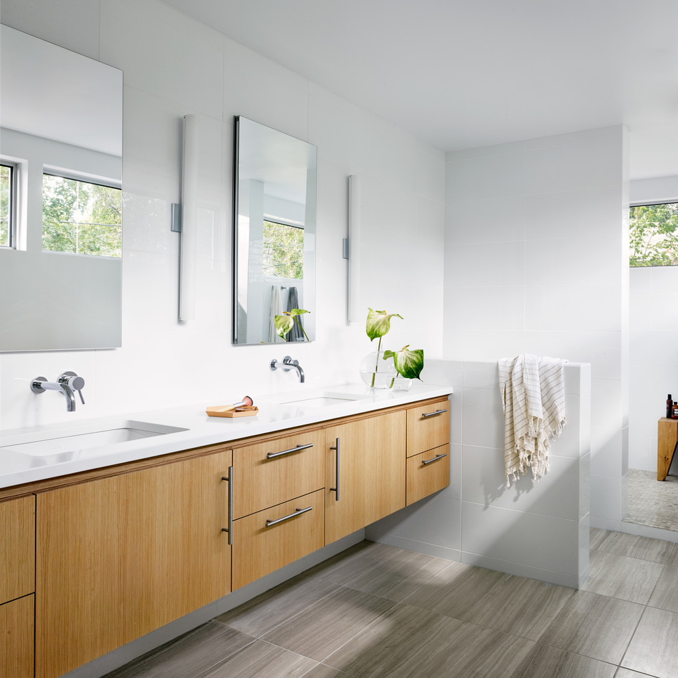 This is an example of a contemporary master bathroom in Austin with an undermount sink, flat-panel cabinets, light wood cabinets and white walls.