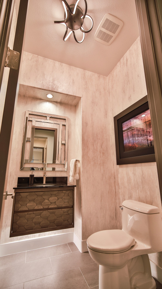 Moderne Gästetoilette mit braunen Schränken, Toilette mit Aufsatzspülkasten, beiger Wandfarbe, grauem Boden, schwarzer Waschtischplatte, schwebendem Waschtisch und Tapetenwänden in Las Vegas