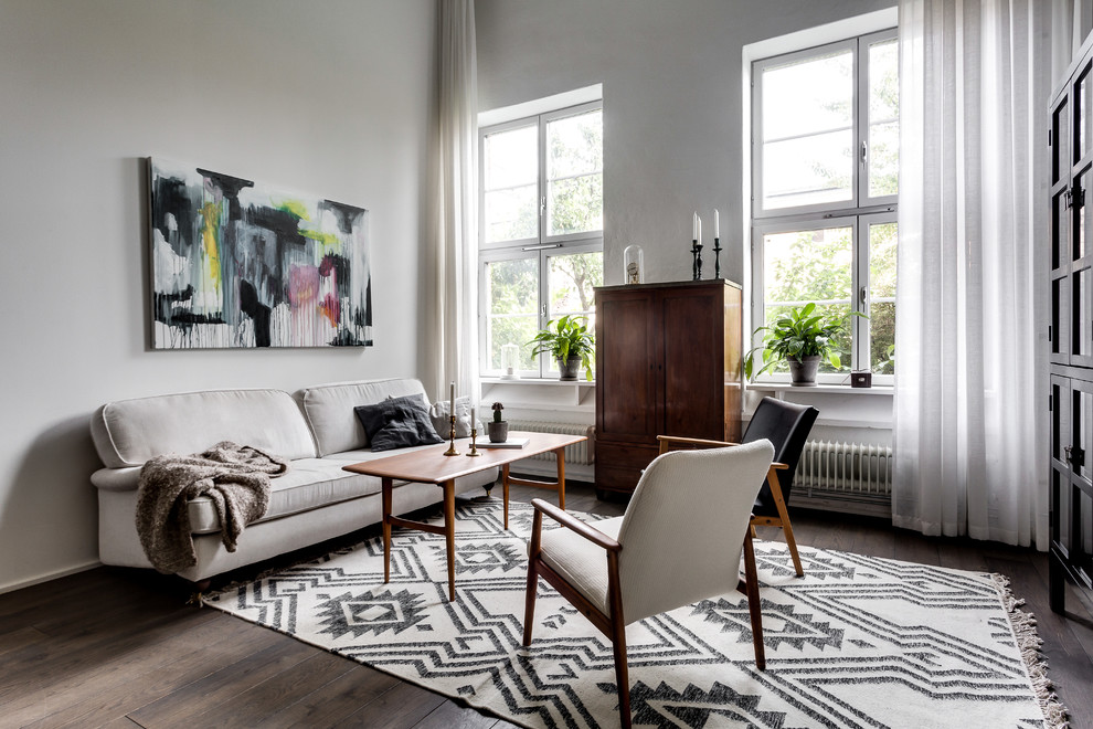 Design ideas for a mid-sized scandinavian formal living room in Stockholm with white walls, dark hardwood floors and no tv.