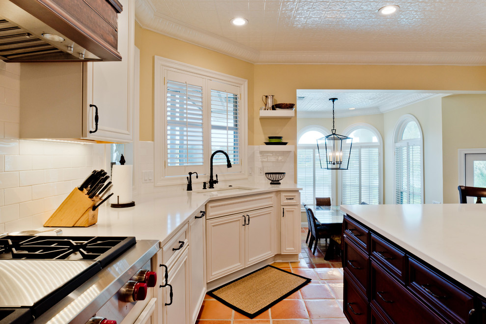 Eat-in kitchen - large transitional u-shaped terra-cotta tile and orange floor eat-in kitchen idea with an undermount sink, recessed-panel cabinets, white cabinets, quartz countertops, white backsplash, subway tile backsplash, stainless steel appliances and an island