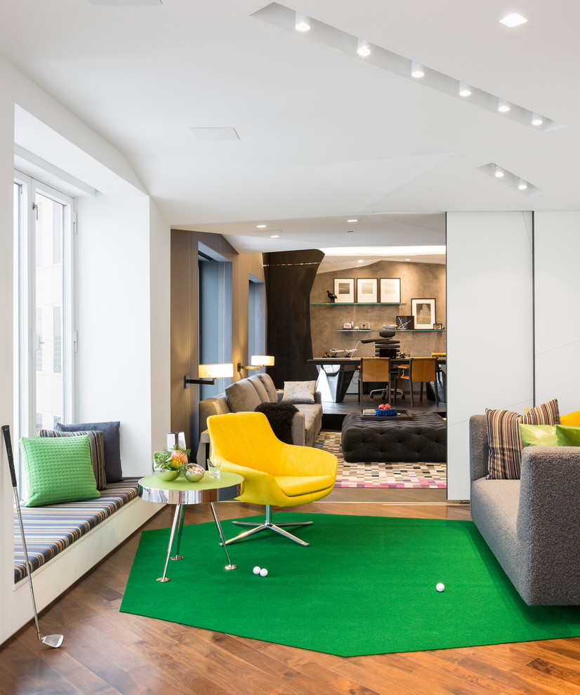 Photo of a mid-sized contemporary enclosed family room in Chicago with a game room, white walls and medium hardwood floors.