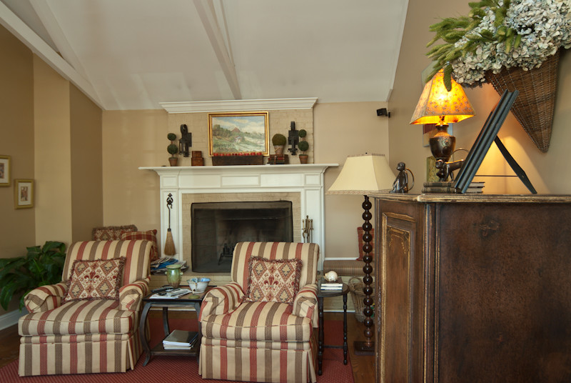 Inspiration for a mid-sized rustic medium tone wood floor kitchen/dining room combo remodel with beige walls, a standard fireplace and a stone fireplace