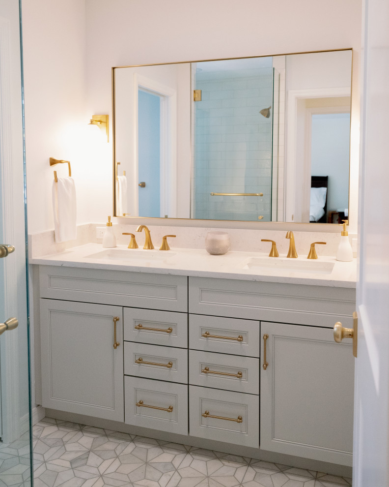 This is an example of a mid-sized transitional 3/4 bathroom in Orlando with beaded inset cabinets, grey cabinets, a corner shower, gray tile, porcelain tile, white walls, porcelain floors, a drop-in sink, engineered quartz benchtops, grey floor, a hinged shower door, white benchtops, an enclosed toilet, a double vanity and a built-in vanity.