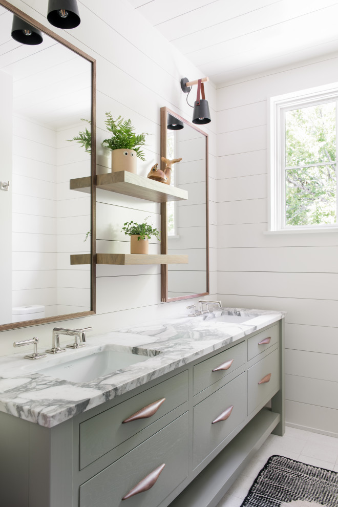 Sullivan's Island Remodel - Upstairs kids, bunk bathroom featuring terrazzo flooring, horizontal shiplap walls, custom inset vanity with white marble countertops, white oak floating shelves, and decorative lighting.