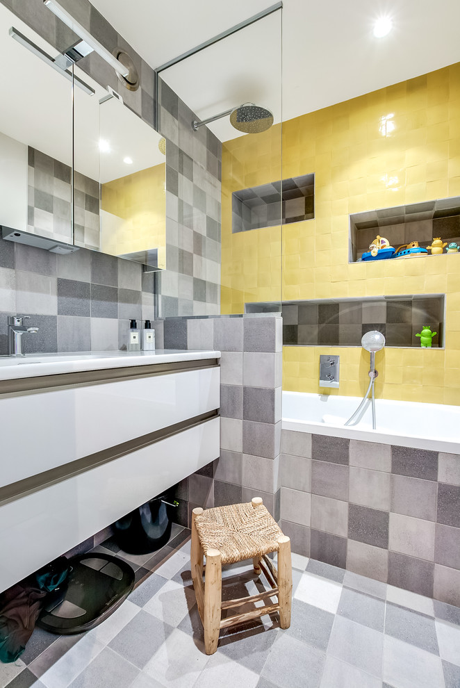 Small contemporary master bathroom in Paris with an undermount tub, a shower/bathtub combo, yellow tile, terra-cotta tile, grey walls, beaded inset cabinets, white cabinets, ceramic floors and a console sink.