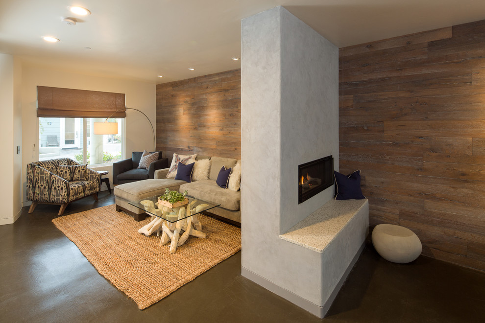 Photo of a mid-sized contemporary formal open concept living room in San Luis Obispo with brown walls, concrete floors, a two-sided fireplace, a concrete fireplace surround, no tv and grey floor.