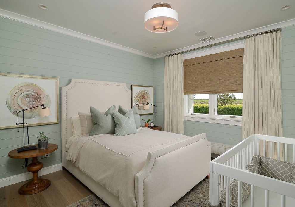 This is an example of a country bedroom in Sacramento with blue walls, medium hardwood floors and brown floor.